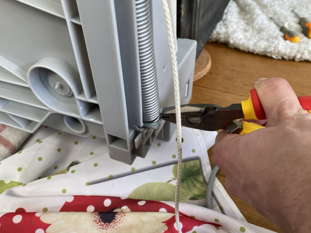 Close-up of a spring holding the door closed.